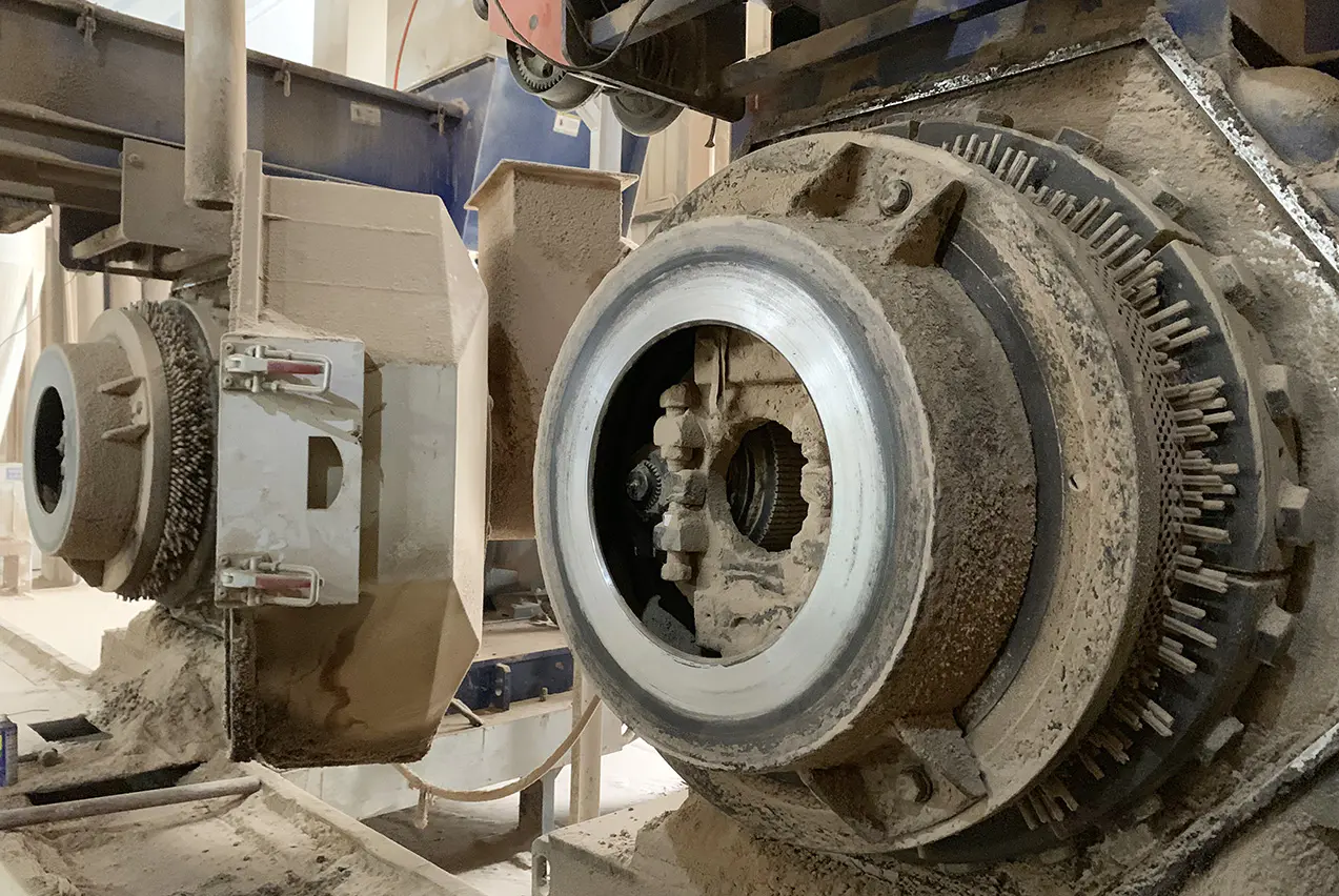Close-up of ring die and roller shell wear components from a rice husk pellet machine
